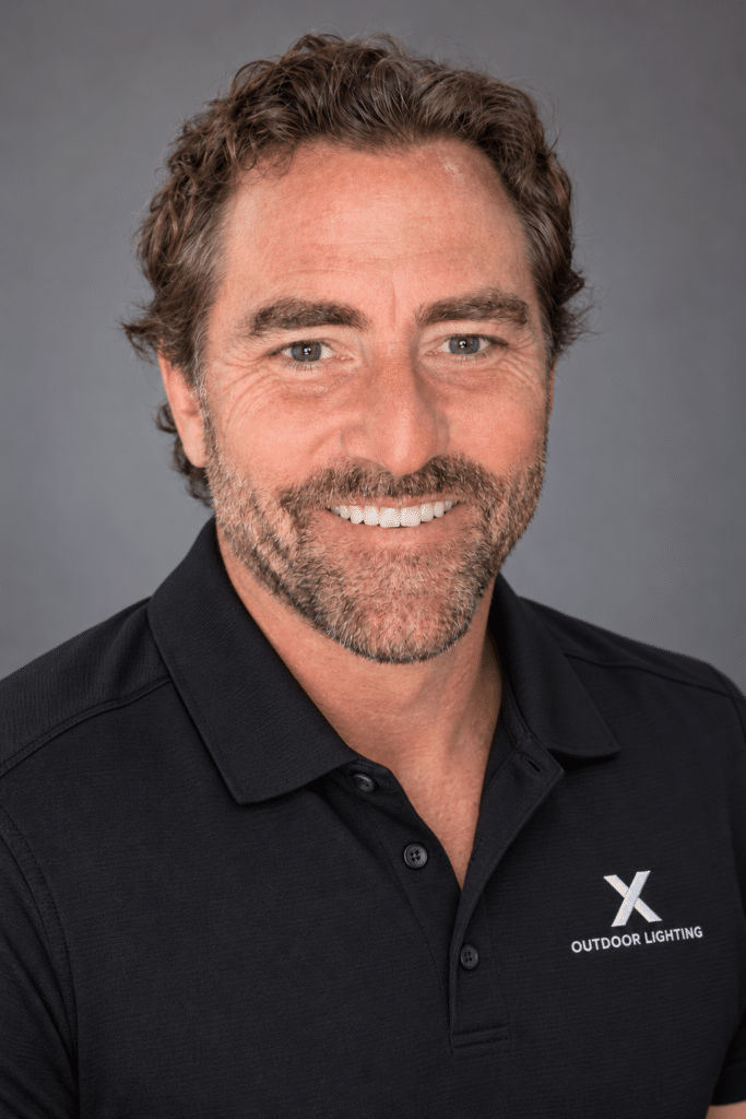 Professional headshot in branded black polo
